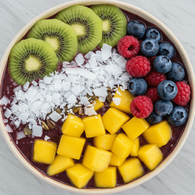Tropical berry acai bowl topped with kiwi, mango, and coconut