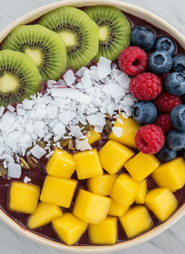 Tropical berry acai bowl topped with kiwi, mango, and coconut